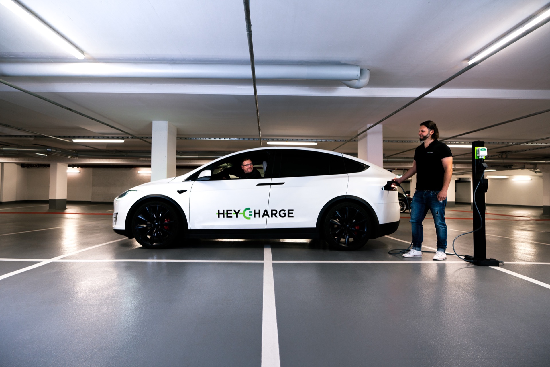Die Gründer von HeyCharge schließen einen Tesla in einer mit HeyCharge ausgestatteten Garage an